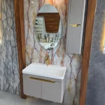 فولست روشویی همراه با آینه‌ بیضی‌شکل بدون قاب با نورپردازی مخفی